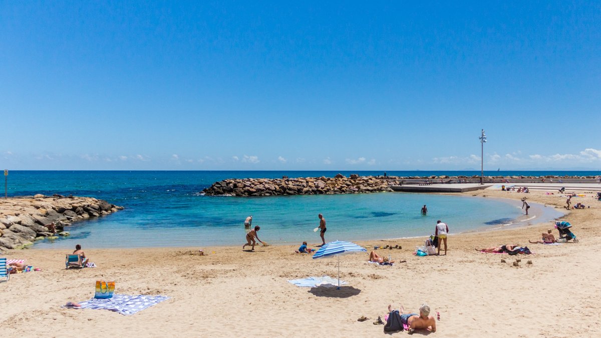 Family relaxing on a sandy beach in Torrevieja on a sunny day